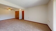 Located at 1000 S Basswood Cir in Bloomington, Indiana, this two-bedroom, one-bathroom unit offers a practical and well-organized single-floor layout. The open kitchen features warm wood-toned cabinetry, a built-in range, refrigerator, and a peninsula counter with a breakfast bar that opens toward the carpeted living area, making the space feel connected and functional. A ceiling fan adds comfort to the main living zone.

Both bedrooms are carpeted and bright, each with windows that bring in natural light and views of surrounding greenery. The spacious primary bedroom includes a large wood-panel sliding closet, while the second bedroom also features a wood-tone closet for ample storage. An additional walk-in closet with wire shelving provides extra organizational space.

The full bathroom is finished with stone-look tile flooring, a wood-toned vanity with storage, and a tub-shower combination. Throughout the unit, warm wood baseboards and trim provide consistent detailing, complementing the neutral walls and light-toned carpeting. A dedicated hallway connects the rooms efficiently, contributing to the overall cohesive flow of the layout. This unit offers a straightforward, comfortable living environment in a residential Bloomington neighborhood.