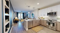 Located at 914 Grays Mill Road in Harrisburg, NC, this thoughtfully designed 2-bedroom, 2-bathroom residence offers a contemporary and cohesive aesthetic throughout its single floor of living space. The open-concept kitchen and living area serves as the heart of the home, where a large peninsula with white quartz countertops and seating for multiple guests flows seamlessly into the living room. The kitchen is equipped with stainless steel appliances, a mix of white upper and light wood-toned lower cabinetry, and stylish pendant lighting overhead. The living room makes a bold design statement with a deep teal accent wall, wood-look flooring, a ceiling fan, and French doors that open to an outdoor balcony, filling the space with natural light. Both bedrooms are serene and well-proportioned, with large windows, soft neutral tones, and ample natural light. The primary suite features a walk-in closet with built-in shelving and a spa-inspired en-suite bathroom with a double-sink vanity, light wood cabinetry, black matte fixtures, and a walk-in tiled shower. The second bathroom mirrors the modern aesthetic with a single-sink vanity and matching black hardware. Durable wood-look flooring runs throughout, unifying the home's clean, modern design.