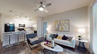 This single-story, 2-bedroom, 2-bathroom residence offers a thoughtfully designed open-concept layout that maximizes functionality and comfort. The living area serves as the heart of the home, featuring wood-style flooring, a ceiling fan, and neutral wall tones that create a bright and welcoming atmosphere. Large windows allow natural light to fill the space, enhancing its airy feel.

The kitchen is outfitted with crisp white cabinetry, granite countertops, a subway tile backsplash, and black appliances, including a range, microwave, and refrigerator. Pendant lighting illuminates a central island with bar seating, making it an ideal space for casual dining or entertaining. A separate dining area provides additional seating options.

Both bedrooms are well-sized, featuring plush carpeting, ceiling fans, and ample natural light from large windows. The primary bedroom connects to a private bathroom equipped with a glass-enclosed, marble-tiled walk-in shower and a spacious walk-in closet with built-in shelving. The second bathroom features a granite vanity and a tub-shower combination with tile surround.

A dedicated in-unit laundry area with a full-size washer and dryer adds everyday convenience, rounding out this well-equipped residence.
