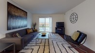 This thoughtfully designed two-bedroom, one-bathroom residence in Dundee, Michigan offers a comfortable and modern single-floor layout. The living room serves as the heart of the home, featuring rich hardwood flooring, a sliding glass door that opens to a private balcony, and sweeping views of the surrounding landscape, flooding the space with natural light. The galley-style kitchen is well-appointed with warm wood cabinetry, granite countertops, black appliances, and hardwood floors, providing an efficient and stylish workspace. Adjacent to the kitchen, the dining area offers additional hardwood flooring and a clean, open feel ideal for everyday meals or entertaining. The full bathroom is finished with granite countertops, warm wood vanity cabinetry, and tile flooring, lending a polished and functional character. Both bedrooms are carpeted and generously sized, each featuring large windows that frame views of the open countryside, filling the rooms with natural light. One bedroom includes a spacious double-door closet. Throughout the home, neutral tones and clean lines create a cohesive, modern ambiance that is both welcoming and practical. The combination of quality finishes and scenic surroundings makes this residence a standout offering in Dundee, MI.