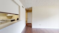 Located at 2210 Sullivan Rd in College Park, GA, this one-bedroom, one-bathroom unit offers a practical and well-organized single-floor layout. The living and dining area is a generous, open space anchored by rich hardwood-style flooring and a textured ceiling. A large sliding glass door fitted with vertical blinds fills the room with natural light and provides outdoor access, while the front entry door opens directly into this central gathering space. The kitchen is efficiently designed with white cabinetry, light granite-style countertops, a stainless steel sink, and black appliances including a dishwasher and range. A pass-through counter connects the kitchen to the living area, enhancing the open feel. The dining area is a separate, intimate space illuminated by a multi-bulb chandelier and finished with the same hardwood-style flooring. The carpeted bedroom offers a comfortable retreat, featuring a large window with outdoor views, a dedicated closet, and direct access to the bathroom. The full bathroom includes a tiled shower-tub combo, wood-style flooring, and a vanity with a granite-style countertop. This unit presents a clean, functional layout well-suited for everyday living.