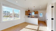 Located at 1300 Mahogany Ave in Bellingham, WA, this well-designed two-story home offers a thoughtful layout spread across two floors. The main level features an open-concept kitchen and living area with light hardwood flooring that enhances the bright, airy atmosphere. The kitchen is a standout, showcasing warm wood cabinetry, a white peninsula with an undermount sink, stainless steel appliances including a refrigerator and microwave, and stylish pendant lighting. Large windows invite generous natural light, framing views of the surrounding neighborhood. A bathroom on the main level features matching wood vanity cabinetry with light countertops and hardwood-style flooring. Upstairs, the two bedrooms are carpeted and well-lit with natural light from large windows. The primary bedroom offers neighborhood views and direct access to an en-suite bathroom. The second bedroom includes a double-door closet and its own adjacent bathroom featuring a full soaking tub with matte black fixtures. A hallway connects the upper-level rooms. Clean white walls and consistent modern finishes carry throughout both floors, creating a cohesive and contemporary feel across the entire home.