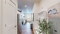 Located at 1111 E Brickyard Rd in Salt Lake City, Utah, this one-bedroom, one-bathroom unit offers a thoughtfully designed, single-floor layout that maximizes every square foot. The open-concept living, dining, and kitchen area serves as the heart of the home, featuring warm hardwood-style flooring and large windows that flood the space with natural light and offer views of the surrounding area. A ceiling fan adds comfort to the airy living room.

The kitchen is outfitted with white shaker-style cabinetry, a classic subway tile backsplash, quartz-style countertops, and a full suite of stainless steel appliances including a refrigerator, range, microwave, and dishwasher. A built-in dining nook provides a compact and functional eating area. A pantry offers additional storage.

The bedroom is a cozy, well-appointed retreat with carpeted flooring and access to a walk-in closet. A hallway entry features a built-in coat rack and bench, adding practical charm. The bathroom includes a glass-enclosed stand-up shower with subway tile surround and wood-look flooring. Completing the unit is a dedicated laundry area and an additional closet for ample storage throughout.
