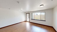 Located at 4116 W Hood River Ave in Spokane, WA, this single-floor, 2-bedroom, 2-bathroom unit offers a functional and comfortable layout. The open living area features durable hardwood-style flooring, crisp white walls with rich dark wood trim, and a large picture window with a glass door that invites natural light and views of the outdoor surroundings. The galley-style kitchen is well-equipped with rich dark wood cabinetry, granite-style countertops, stainless steel appliances including a refrigerator, range, and built-in microwave, a kitchen island, and track lighting overhead. A dedicated laundry room houses a full-size washer and dryer with overhead wire shelving for added storage. Both bedrooms are carpeted and bright, each featuring windows that allow natural light to filter in. The primary bedroom offers a comfortable, generously sized retreat. The two bathrooms are finished with tile flooring and granite-style vanity countertops; one includes a soaking tub and shower combo, while the other features a walk-in shower. A hallway and closet complete the thoughtfully organized floor plan, making this unit a practical and inviting place to call home.