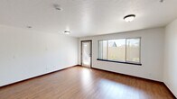 Located at 4116 W Hood River Ave in Spokane, WA, this single-floor, 2-bedroom, 2-bathroom unit offers a functional and comfortable layout. The open living area features durable hardwood-style flooring, crisp white walls with rich dark wood trim, and a large picture window with a glass door that invites natural light and views of the outdoor surroundings. The galley-style kitchen is well-equipped with rich dark wood cabinetry, granite-style countertops, stainless steel appliances including a refrigerator, range, and built-in microwave, a kitchen island, and track lighting overhead. A dedicated laundry room houses a full-size washer and dryer with overhead wire shelving for added storage. Both bedrooms are carpeted and bright, each featuring windows that allow natural light to filter in. The primary bedroom offers a comfortable, generously sized retreat. The two bathrooms are finished with tile flooring and granite-style vanity countertops; one includes a soaking tub and shower combo, while the other features a walk-in shower. A hallway and closet complete the thoughtfully organized floor plan, making this unit a practical and inviting place to call home.