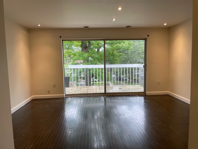 Living room balcony overlooks shaded courtyard. - 3240 Hewitt Ave