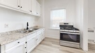 Located at 1501 W Adams Blvd in Los Angeles, CA, this efficient one-bedroom, one-bathroom unit offers a well-organized layout across a single floor. Light wood-style flooring runs throughout the space, creating a clean, cohesive look that enhances the bright, airy atmosphere.

The bedroom is a comfortable, well-proportioned room featuring two windows that invite generous natural light and offer street views. A ceiling fan adds practical comfort, and crisp white walls keep the space feeling open.

The kitchen is thoughtfully appointed with white shaker-style cabinetry, granite-look countertops, a double-basin sink with a matte black faucet, and stainless steel appliances including a gas range and refrigerator. A window above the counter provides additional natural light, making the space pleasant for cooking and meal prep.

A hallway connects the main rooms and provides access to a dedicated closet for storage. The bathroom features a tiled walk-in shower and matches the clean, minimal aesthetic of the rest of the unit.

Overall, the space presents a bright, move-in-ready interior with consistent finishes, practical storage, and a straightforward layout — well-suited for those seeking a functional and low-maintenance home in central Los Angeles.