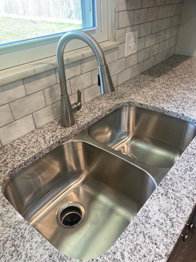 Remodeled Kitchen with granite counters, tile backsplash, and new appliances - 174 Brisbane Ave