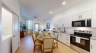 Located at 1000 Sweetbay Haven Lane in Apex, NC, this one-bedroom, one-bathroom residence offers a well-designed single-level layout with modern finishes throughout. The open-concept main living area seamlessly combines the kitchen, dining room, and living room into one bright, welcoming space. Light wood-look flooring flows underfoot, while recessed lighting and a ceiling fan enhance the airy atmosphere. Large windows dressed with elegant floor-to-ceiling drapes invite abundant natural light and provide views of the outdoors.

The kitchen is outfitted with white shaker-style cabinetry, granite countertops, a black matte sink fixture, and a full suite of stainless steel appliances, including a refrigerator, range, microwave, and dishwasher. The adjoining dining area comfortably accommodates a round table, ideal for everyday meals or entertaining.

The primary bedroom is a comfortable retreat featuring plush carpeting, a bold blue accent wall, and a natural light-filled window. A spacious walk-in closet with wire shelving provides generous storage. The bathroom includes granite countertops, white cabinetry, and wood-look flooring. Additional highlights include a dedicated laundry area, a utility room, three closets, and a private patio for outdoor enjoyment.