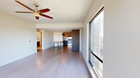 Located at 2144 E Republic Rd in Springfield, MO, this well-appointed 2-bedroom, 3-bathroom single-floor unit offers a thoughtfully designed layout with modern finishes throughout. The open-concept living and kitchen area serves as the heart of the space, featuring wide-plank hardwood-style flooring, a ceiling fan, and expansive floor-to-ceiling windows that flood the room with natural light and provide outdoor views. The kitchen is outfitted with two-tone cabinetry — light upper cabinets paired with darker lower drawers — stainless steel appliances, dark countertops, and striking pendant lighting above a butcher block island that doubles as a dining surface. The generously sized primary bedroom includes plush carpet, a ceiling fan, large windows, and direct access to a private balcony. The second bedroom is equally comfortable, also featuring carpet and a ceiling fan. Hallways are bright and efficiently laid out, with warm wood-toned sliding closet doors adding a contemporary touch. The three bathrooms are finished with floating wood-grain vanities, dark countertops, large backlit mirrors, and tile flooring. The primary bathroom features a sleek glass-enclosed walk-in shower with neutral tile surround. Throughout the unit, clean white walls and consistent modern finishes create a cohesive, contemporary aesthetic.