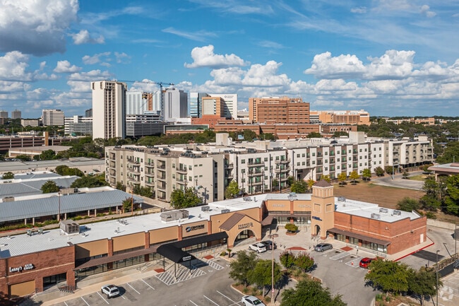 Large apartment building with retail stores next door in the Medical Center neighborhood.