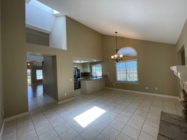 Family room with vaulted ceiling and raised hearth fireplace - 26056 Bancroft St