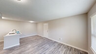 Located at 201 SE 89th St in Oklahoma City, Oklahoma, this single-story, one-bedroom, one-bathroom unit offers a smartly designed layout that maximizes every square foot. The living area features neutral-toned walls, light gray wood-look vinyl plank flooring, and a textured ceiling, creating a clean and contemporary aesthetic throughout.

The kitchen is a standout feature, equipped with stainless steel appliances including a refrigerator, microwave, and range. Gray cabinetry with ample storage lines the walls, complemented by white quartz countertops and a breakfast bar with an under-mount sink — ideal for casual dining or meal prep. The open pass-through design connects the kitchen to the main living area, enhancing the sense of openness.

The bedroom is a well-proportioned retreat with a ceiling fan, a window that brings in natural light and outdoor views, a closet, and direct access to the bathroom. The bathroom features a white quartz vanity countertop, an under-mount sink, a mirrored medicine cabinet, and textured walls that add subtle character.

Clean white trim, consistent flooring, and a cohesive neutral color palette tie the entire space together, making it a practical and move-in-ready home.