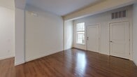 Located at 3214 Dunlap Ln in Mechanicsburg, PA, this well-appointed one-bedroom, two-bathroom residence offers a thoughtfully designed single-floor layout. The open-concept kitchen and living area serves as the heart of the home, featuring rich hardwood flooring, dark espresso cabinetry, granite countertops, a central island with pendant lighting, and a full suite of stainless steel appliances including a refrigerator, range, microwave, and dishwasher — ideal for both everyday living and entertaining.

The spacious bedroom is finished with plush carpeting and includes a large window that brings in natural light and outdoor views. An attached walk-in closet provides ample storage with wire shelving systems along multiple walls. Both bathrooms are clean and modern, one featuring a full soaking tub with shower, and the other offering a vanity with a large mirror and dark cabinetry complementing the hardwood floors throughout.

A dedicated laundry room houses a full-size washer and dryer, adding everyday convenience. The living area extends from the kitchen with additional hardwood flooring and an open, airy feel. The consistent use of neutral tones, crisp white walls, and quality finishes throughout creates a cohesive and inviting atmosphere.