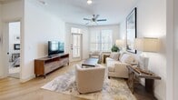 This thoughtfully designed 2-bedroom, 2-bathroom single-story residence offers a comfortable and functional open-concept floor plan. Light wood flooring flows seamlessly through the main living areas, creating a bright and cohesive aesthetic throughout.

The kitchen serves as a central hub of the home, featuring sage-toned cabinetry, a white subway tile backsplash, stainless steel appliances, and a granite-topped island with bar seating illuminated by elegant pendant lighting. A built-in desk nook and open shelving add both practicality and character.

The open layout connects the kitchen to the dining area and a spacious living room, which is bathed in natural light from large windows and features a ceiling fan and direct access to an exterior door.

The primary bedroom offers a generous footprint with plush carpeting, ample natural light, and a ceiling fan. It is complemented by a walk-in closet with multi-level shelving and a private en-suite bathroom showcasing dual granite vanities, gray cabinetry with matte black hardware, and a glass-enclosed shower. The second bedroom is equally bright and comfortable, with carpeted flooring, large windows, and its own closet. Additional spaces include a laundry room, pantry, and a connecting hallway, rounding out a well-organized and livable floor plan.