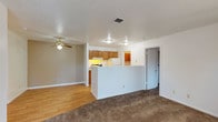Located at 3901 NE Montgomery Blvd in Albuquerque, New Mexico, this single-floor unit offers a practical and well-organized layout with a variety of functional living spaces. The open-concept living and dining area features plush carpeting, a ceiling fan, and a textured ceiling, creating a comfortable and inviting atmosphere. A classic fireplace with a black mantel anchors one wall of the living area, complemented by a window that allows natural light to filter in.

The kitchen is positioned at the heart of the unit, separated from the living space by a peninsula counter. Warm wood cabinetry lines the walls, providing ample storage, while the kitchen is equipped with a coil electric range and a full-size refrigerator. Adjacent to the kitchen, a dedicated laundry area with hardwood-style flooring and overhead cabinetry offers added convenience.

The bedrooms are carpeted and generously sized, with one featuring a sliding glass door that opens to an outdoor view and a built-in closet. Additional bedrooms include large windows that bring in natural light. The bathrooms are clean and efficiently designed, each featuring a tiled tub-shower combination, a toilet, and hardwood-style flooring. The overall aesthetic of the unit is neutral and well-maintained, offering a move-in-ready living environment.