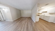 Located at 8401 Spain Rd NE in Albuquerque, New Mexico, this two-bedroom, one-bathroom single-floor residence offers a practical and well-appointed layout with thoughtful modern updates throughout. The open living area greets you with warm wood-look luxury vinyl flooring, neutral beige walls, and a textured ceiling that adds dimension to the space. Natural light filters in through blinds-fitted windows, creating a bright and welcoming atmosphere. A hallway connects the living area to the rest of the home, maintaining a clear and efficient flow between rooms.

The galley-style kitchen is a standout feature, outfitted with crisp white cabinetry, light countertops, a stainless steel sink, and a full suite of stainless steel appliances including a refrigerator, range, dishwasher, and over-the-range microwave. Track lighting overhead ensures the workspace is well-lit.

Both bedrooms are comfortably sized, featuring plush neutral carpeting, ceiling fans, and ample natural light from windows with blinds. The primary bedroom offers generous space, while the second bedroom also benefits from built-in cabinetry. The full bathroom includes a tub-shower combination with clean white surround, a vanity with white cabinetry, and wood-look flooring. A dedicated closet and hallway complete this efficient, move-in-ready home.