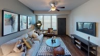 Located in Oswego, Illinois, this single-floor residence offers a thoughtfully designed layout that balances comfort and modern style. The open living area serves as the heart of the home, featuring warm hardwood-style flooring, neutral wall tones, large windows with slatted blinds that invite generous natural light, and a ceiling fan overhead. The space accommodates both relaxed lounging and entertaining with ease.

The kitchen is a standout feature, showcasing sleek dark cabinetry paired with granite-style countertops, stainless steel appliances including a refrigerator, range, and microwave, and a double-basin sink. A built-in wine rack adds a distinctive touch, while the generous counter space makes the kitchen as functional as it is attractive.

The bedrooms are comfortably sized, each with plush carpeting, ample natural light from well-placed windows, and neutral walls that create a calm, restful atmosphere. The primary bathroom features a dual-sink vanity with dark cabinetry and granite countertops, complementing the kitchen's aesthetic. A secondary bathroom includes a full tub and shower combination with wood-look flooring, providing practical functionality.

Overall, the residence presents a cohesive contemporary design with consistent finishes, creating a polished and inviting living environment.