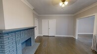 Located at 2872 Mayfield Rd in Cleveland Heights, OH, this single-floor, one-bedroom, one-bathroom unit offers a well-appointed layout across a comfortable footprint. The space features two connected living areas adorned with elegant crown molding, dark hardwood floors, and a striking decorative brick fireplace that serves as a natural focal point. Multiple windows invite natural light throughout, while classic cast-iron radiators underscore the home's timeless character. A ceiling fan light fixture completes the living area's warm, functional aesthetic.

The kitchen is outfitted with rich wood cabinetry, granite countertops, and a full suite of stainless steel appliances, including a gas range, microwave, and dishwasher. A wall-mounted granite breakfast counter and a separate exterior door add convenience to this well-designed culinary space.

The bedroom is carpeted for comfort, features its own cast-iron radiator, and receives natural light through a pair of windows. A dedicated closet provides practical storage. The bathroom includes a vanity with storage and a built-in cabinet, with luxury vinyl flooring and a radiator rounding out the space. A hallway connects the rooms, completing this cohesive and characterful Cleveland Heights residence.