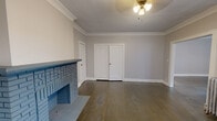 Located at 2872 Mayfield Rd in Cleveland Heights, OH, this single-floor, one-bedroom, one-bathroom unit offers a well-appointed layout across a comfortable footprint. The space features two connected living areas adorned with elegant crown molding, dark hardwood floors, and a striking decorative brick fireplace that serves as a natural focal point. Multiple windows invite natural light throughout, while classic cast-iron radiators underscore the home's timeless character. A ceiling fan light fixture completes the living area's warm, functional aesthetic.

The kitchen is outfitted with rich wood cabinetry, granite countertops, and a full suite of stainless steel appliances, including a gas range, microwave, and dishwasher. A wall-mounted granite breakfast counter and a separate exterior door add convenience to this well-designed culinary space.

The bedroom is carpeted for comfort, features its own cast-iron radiator, and receives natural light through a pair of windows. A dedicated closet provides practical storage. The bathroom includes a vanity with storage and a built-in cabinet, with luxury vinyl flooring and a radiator rounding out the space. A hallway connects the rooms, completing this cohesive and characterful Cleveland Heights residence.