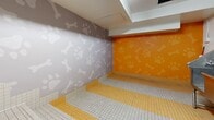 Located at 945-955 Reunion Avenue in Victoria, BC, this purpose-built pet cleaning facility offers a compact yet fully equipped space designed specifically for pet grooming and washing. The room features a large, commercial-grade stainless steel wash tub complete with built-in faucet hardware, a retractable hose, and a ramp panel for easy pet access — making bath time convenient for pets of all sizes.

The tiled flooring combines white and yellow mosaic tiles in alternating stripes, providing both a visually clean aesthetic and a slip-resistant surface well-suited for a wet environment. A central floor drain ensures efficient water management. Tiered tiled steps along one wall add further accessibility for larger animals.

The walls are decorated with a lively pattern of paw prints and bones rendered in contrasting tones — vibrant orange on one side and soft grey on the other — giving the space a welcoming, pet-friendly atmosphere. Overhead fluorescent lighting ensures the room is well-lit throughout.

The facility is equipped with visible plumbing infrastructure, a fire suppression system, and a posted "Pet Cleaning Facility Rules" sign, reflecting a thoughtfully managed shared amenity. A grey access door with a window provides entry to the room. The space is practical, clean, and purpose-driven, serving as a convenient amenity for pet owners in the surrounding residential community.