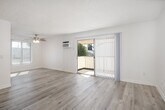 Located at 201 N Wayfield St in Orange, California, this well-appointed one-bedroom, two-bathroom residence offers a thoughtfully designed single-floor layout. The open-concept living, dining, and kitchen area serves as the heart of the home, filled with natural light from large sliding glass doors that lead to a private balcony with outdoor views of surrounding greenery. Light wood-style flooring flows throughout the main living areas, complemented by a textured ceiling and a ceiling fan that adds both function and character.

The galley-style kitchen is efficiently designed with crisp white cabinetry, granite countertops, stainless steel appliances including a range, microwave, and dishwasher, and a double-basin sink. A pantry provides additional storage. The kitchen opens directly into the dining and living space, creating a seamless flow ideal for everyday living.

The bedroom features plush carpeting, a ceiling fan, and a window with vertical blinds allowing natural light. Three closets throughout the unit offer generous storage. Both bathrooms are finished with granite-topped vanities, white cabinetry, and tub/shower combinations featuring stone-patterned surrounds and sliding glass enclosures. The clean, neutral palette and consistent finishes create a cohesive and comfortable ambiance throughout.