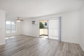 Located at 201 N Wayfield St in Orange, California, this well-appointed one-bedroom, two-bathroom residence offers a thoughtfully designed single-floor layout. The open-concept living, dining, and kitchen area serves as the heart of the home, filled with natural light from large sliding glass doors that lead to a private balcony with outdoor views of surrounding greenery. Light wood-style flooring flows throughout the main living areas, complemented by a textured ceiling and a ceiling fan that adds both function and character.

The galley-style kitchen is efficiently designed with crisp white cabinetry, granite countertops, stainless steel appliances including a range, microwave, and dishwasher, and a double-basin sink. A pantry provides additional storage. The kitchen opens directly into the dining and living space, creating a seamless flow ideal for everyday living.

The bedroom features plush carpeting, a ceiling fan, and a window with vertical blinds allowing natural light. Three closets throughout the unit offer generous storage. Both bathrooms are finished with granite-topped vanities, white cabinetry, and tub/shower combinations featuring stone-patterned surrounds and sliding glass enclosures. The clean, neutral palette and consistent finishes create a cohesive and comfortable ambiance throughout.
