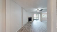 Located in Sun Valley Village in Altamonte Springs, FL, this one-bedroom, one-bathroom residence offers a well-organized single-floor layout with a comfortable and functional design throughout. The open-concept living and dining area is a standout feature, showcasing light wood-look flooring, a textured ceiling, and a ceiling fan. A tile-surround fireplace serves as a natural focal point, while sliding glass doors flood the space with natural light and provide outdoor access. The kitchen is efficiently designed in a galley style, featuring rich wood cabinetry, dark granite countertops, tile flooring, and black appliances including a range, microwave, and refrigerator. A dedicated laundry room offers side-by-side washer and dryer hookups along with built-in wire shelving for added storage convenience. The spacious bedroom includes light wood-look flooring, a ceiling fan, and a wide wall-to-wall closet with louvered bi-fold doors offering generous storage capacity. The full bathroom is appointed with a wood vanity, dark granite countertop, tile flooring, and a full-size tub-shower combination. Clean neutral tones and consistent finishes throughout give the space a cohesive and move-in-ready feel.