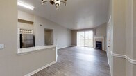 Located at 4525 Champions View in Colorado Springs, Colorado, this single-floor residence offers a thoughtfully designed open-concept layout finished with a neutral, contemporary palette. The main living area is anchored by a tiled fireplace and features durable wood-look flooring that flows seamlessly throughout the common spaces. A large sliding glass door floods the living room with natural light while providing access to the outdoors.

The kitchen is a functional highlight, showcasing two-tone cabinetry with white uppers and slate-gray lowers, a classic white subway tile backsplash, stainless steel appliances including a refrigerator, range, and built-in microwave, and a marble-look countertop peninsula with a deep single-basin sink. A stylish chandelier overhead adds an elevated finishing touch.

The bedrooms are carpeted for comfort and feature neutral walls, ceiling fans, and ample natural light from well-placed windows. At least one bedroom includes a walk-in closet. The bathrooms are cleanly finished with white tub-shower combinations, wood-look flooring, and brushed nickel fixtures. The overall ambiance is clean, modern, and move-in ready.