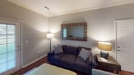 Located at 1400 Center Point Dr in Knoxville, Tennessee, this single-floor unit offers a thoughtfully designed layout with a cohesive neutral color palette throughout. The open living area features rich hardwood-style flooring, crown molding, and soft ambient lighting, creating a welcoming atmosphere. A decorative mirror and coordinating furnishings add character to the living space, while an adjacent dining area is highlighted by a pendant light fixture and the same elegant crown molding detail.

The galley-style kitchen is well-equipped, featuring warm wood cabinetry, white countertops, a stainless steel sink, and black appliances including a refrigerator, range, and microwave. A louvered pantry door provides additional storage, and the hardwood-style flooring continues seamlessly throughout.

The bedrooms are carpeted for comfort, with one featuring a ceiling fan and natural light from a window, and another versatile room offering open shelving and a walk-in closet. Both bathrooms include warm wood vanities with tile flooring; one features a shower-tub combo, while the other includes a separate tub with a large vanity mirror and a well-lit fixture. Overall, the space presents a practical and comfortable living environment.