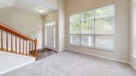 Located at 10090 Mill Run Cir in Owings Mills, MD, this multi-level home offers three bedrooms, three bathrooms, and a well-distributed layout spread across four floors. The entry level welcomes with soaring two-story ceilings, large windows flooding the foyer and living room with natural light, and hardwood-style flooring that transitions into plush carpet. The living room is anchored by a classic fireplace and features a wood-banistered staircase, adding warmth and character to the open space. The kitchen is well-appointed with white cabinetry, dark granite countertops, light wood-style flooring, and multiple windows offering pleasant outdoor views — ideal for everyday cooking and entertaining. Bedrooms are carpeted and generously sized, including a spacious primary suite with a walk-in closet featuring wire shelving and a private window with views of surrounding greenery. The bathrooms are clean and functional, featuring white vanities, tub-shower combinations, and wood-look flooring. An attached two-car garage with an automatic opener provides convenient parking and additional storage. Throughout, neutral tones, plentiful natural light, and a practical multi-floor plan create a comfortable and inviting living environment.