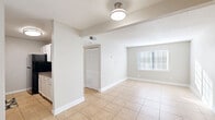 Located at 1 Lakeside Rd in Greenville, SC, this single-floor, two-bedroom, one-bathroom home offers a practical and well-organized layout with consistent light tile flooring throughout. The open living room is bright and airy, benefiting from a large window that allows generous natural light to fill the space, complemented by neutral warm-gray walls and clean white baseboards.

The galley-style kitchen is a standout feature, outfitted with white cabinetry, dark granite-style countertops, a mosaic tile backsplash, and black appliances including a range, refrigerator, and under-cabinet range hood. The efficient layout maximizes counter and storage space on both sides of the kitchen.

The spacious primary bedroom receives abundant natural light through large windows, with a bifold closet offering generous storage. The second bedroom is similarly well-lit with a window and direct hallway access. Throughout the home, five closets provide exceptional storage flexibility. A hallway connects the bedrooms to the full bathroom, which features a combined tub and shower. The textured ceilings and consistent neutral palette lend the home a clean, move-in-ready appearance suited for comfortable everyday living.