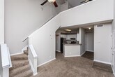 Located at 1224 Defoor Village Ct in Atlanta, GA, this two-story home offers a well-designed layout with distinctive architectural details throughout. The upper level is highlighted by dramatic vaulted ceilings that soar to a peak, with a striking triangular window that floods the space with natural light and creates an airy, open atmosphere. Plush carpeting runs through the living areas and bedrooms, adding warmth underfoot.

The kitchen is thoughtfully appointed with crisp white cabinetry, speckled stone countertops, a subway tile backsplash, and stainless steel appliances including an electric range. A breakfast bar provides casual seating and connects the kitchen to the adjacent living area. The open sightlines between rooms enhance the overall sense of flow and connectivity.

Living spaces benefit from ceiling fans and generous windows, while French doors in one room open directly onto a private balcony with outdoor views, ideal for relaxing or entertaining. The bathroom features wood-look flooring, a tub/shower combination with classic tile accents, and a built-in closet with wire shelving for organized storage. Additional bedrooms feature vaulted ceilings and ample natural light. The home's neutral color palette and clean finishes create a versatile, move-in ready environment throughout.