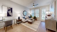 This thoughtfully designed single-floor residence offers a functional and comfortable layout with 1 bedroom, 1 bathroom, and an impressive four closets for exceptional storage. Light wood-tone flooring runs consistently throughout, lending warmth and cohesion to the entire space.

The open-concept kitchen and living area form the heart of the home. The kitchen features white shaker cabinetry, a subway tile backsplash, stainless steel appliances, a central island with bar seating, and recessed lighting overhead. The living room flows naturally from the kitchen, highlighted by large windows with slatted blinds and a glass door that invites abundant natural light and outdoor views. A ceiling fan adds both function and style.

The bedroom is generously sized, with dual windows, a ceiling fan, and direct access to the full bathroom. The bathroom offers a long white vanity with dual sinks, wood-tone flooring, and a shower-tub combination. A spacious walk-in closet with multi-level shelving and hanging rods provides excellent organization potential. Additional closets throughout the unit offer further versatility.

A dedicated laundry area adds everyday convenience, while the neutral gray and white palette throughout creates a clean, modern ambiance that is both inviting and highly functional.