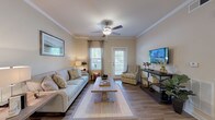 Located at 3500 Pinckney Marsh Ln in Summerville, SC, this single-story residence offers a thoughtfully designed layout with consistent, modern finishes throughout. The living room serves as the heart of the home, featuring warm hardwood-style flooring, crown molding, a ceiling fan, and abundant natural light streaming through multiple windows and a glass-paned door. The open, inviting atmosphere is well-suited for both relaxing and entertaining.

The kitchen is equipped with dark espresso cabinetry, granite countertops, stainless steel appliances including a range, microwave, dishwasher, and refrigerator, along with a undermount sink — a combination that balances style and functionality.

The bedrooms are carpeted and feature ceiling fans, natural light from windows with blinds and draping curtains, and a calm, neutral color palette that promotes restful comfort.

The bathrooms echo the kitchen's design language with matching dark cabinetry, granite countertops, and large mirrors. One bathroom includes a soaking tub with shower combination, while another features a walk-in shower, providing versatile options for residents.

Completing the home is a dedicated laundry room housing a full-size washer and dryer set, complemented by wire shelving for additional storage. The space throughout maintains a cohesive, warm aesthetic ideal for everyday living.