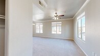Located at 301 Gibson Dr in Roseville, CA, this two-story home offers a thoughtfully designed layout across its two levels. The main living floor hosts a generously sized living room bathed in natural light from multiple large windows, accented by crown molding and a ceiling fan with a light fixture. An elegant chandelier adds a refined touch, while plush carpeting underfoot creates a warm, inviting ambiance. The kitchen is outfitted with crisp white cabinetry, dark countertops, wood-look flooring, and a full suite of stainless steel appliances including a refrigerator, range, and over-the-range microwave. A convenient pass-through connects the kitchen to the living area. The spacious primary bedroom features a ceiling fan, a sliding glass door opening to a private balcony with neighborhood views, and direct access to two closets — including a walk-in closet with built-in shelving and hanging rods. The full bathroom is clean and functional, offering a tub-shower combination, wood-look flooring, and a vanity with dark countertops. The attached garage on the ground level provides secure parking and additional storage. Staircases connect both floors seamlessly, completing this well-appointed Roseville home.