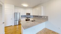 Located at 250 Celebration Ct in Middletown, Delaware, this well-appointed two-bedroom, one-bathroom residence offers a thoughtfully designed single-floor layout. Light-toned hardwood flooring flows consistently throughout, creating a warm and cohesive aesthetic across every room.

The kitchen is a standout feature, showcasing crisp white shaker cabinetry, granite countertops, a stylish geometric tile backsplash in soft blue-grey tones, and a full suite of stainless steel appliances including a gas range, over-the-range microwave, refrigerator, and dishwasher. A peninsula with an integrated sink adds both workspace and a natural transition into the adjacent living area.

The living room is bright and open, benefiting from abundant natural light through a large sliding glass door that leads to a private balcony with outdoor views. A ceiling fan adds comfort, while the tray ceiling detail lends architectural interest to the space.

The primary bedroom is generously proportioned, featuring dual windows, a ceiling fan, and a closet with a full-width hanging rod. The second bedroom is equally well-lit with access to closet space. The bathroom is finished with marble-style tile in the shower surround, granite countertops, and hardwood flooring, maintaining the upscale finishes found throughout the home.