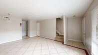 This two-story, one-bedroom, two-bathroom home in Houston's 77036 area is thoughtfully laid out across two floors. The main level features a welcoming entrance that opens into a spacious living room finished with light ceramic tile flooring and neutral-toned walls, bathed in natural light from a large window. A carpeted staircase connects the two levels. The galley-style kitchen is well-equipped with dark cabinetry, granite-look countertops, a tile backsplash, and black appliances including a range, refrigerator, and dishwasher, alongside a double-basin sink. A pantry and multiple closets provide ample storage throughout the home. Both bathrooms are finished with tile flooring; one includes a full tub-shower combination. The upper level hosts the generously sized primary bedroom, which features tile flooring, a ceiling fan, and a sliding glass door leading to a private balcony with outdoor views. An en-suite bathroom with dark vanity cabinetry is directly accessible from the bedroom. With six closets distributed across the home, storage is a notable highlight. The neutral color palette and tile flooring throughout lend a clean, cohesive look to the entire space.