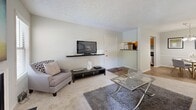 Located at 600 Old Covington Hwy in Roswell, GA, this one-bedroom, two-bathroom residence offers a well-organized single-level floor plan that makes efficient use of its space. The living room serves as the heart of the home, featuring plush carpeting, a textured ceiling, a cozy fireplace, and a window that invites natural light. The open layout connects seamlessly to a dedicated dining area, which is finished with warm wood-look flooring and illuminated by a modern chandelier overhead. The galley-style kitchen runs parallel walls of warm wood cabinetry paired with dark countertops and stainless steel appliances, including a range, refrigerator, and dishwasher — providing ample storage and functionality. The bedroom is a comfortable retreat, carpeted for warmth and featuring wall-mounted shelving, a sliding glass door that opens to the outside, and direct access to a dedicated walk-in closet. Two full bathrooms serve the residence, each clean and bright with tiled tub-shower combinations. A hallway connects the private areas of the home with ease. Neutral tones and consistent finishes throughout lend the space a cohesive, move-in-ready feel suited for comfortable everyday living.