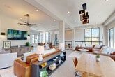 Located at 13525 Grayson Hi Cir in Dale City, Virginia, this thoughtfully designed single-floor community amenity space offers a sophisticated and welcoming environment for gathering, collaboration, and relaxation. The open-plan layout is anchored by a spacious lounge area featuring plush leather seating, layered area rugs over carpeted floors, and a curated mix of modern pendant and chandelier lighting that adds a striking visual element overhead. Structural columns punctuate the space without disrupting its airy flow.

A dedicated seating zone with round natural wood tables and cognac leather chairs provides a casual dining and social area, set against bold navy accent walls that contrast elegantly with the crisp white ceilings and light-toned tile flooring. Floor-to-ceiling windows with sleek black frames flood the interior with natural light while framing panoramic views of the surrounding neighborhood and lush tree canopy.

A private conference or meeting room, finished with deep navy walls and linear ceiling lighting, opens directly onto an outdoor patio through full-width folding glass doors. The patio extends the usable space outdoors, offering an elevated al fresco setting with open views. Recessed lighting throughout and carefully chosen décor complete the polished, contemporary aesthetic of this well-appointed community space.