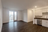 Located at 1547 Pacific Ave in Santa Cruz, CA, this modern 4-bedroom, 2-bathroom unit offers a thoughtfully designed single-floor layout. The open-concept living and kitchen area is anchored by warm hardwood-style flooring and recessed lighting throughout. Sliding glass doors lead to a private balcony, allowing natural light to pour into the living space and offering pleasant outdoor views of the surrounding neighborhood.

The kitchen is well-appointed with white shaker-style cabinetry, dark stone countertops, a stainless steel sink, and a full suite of stainless steel appliances including a refrigerator, range, microwave, and dishwasher. The clean, neutral palette creates a bright and functional cooking space.

The four bedrooms are comfortably sized, with the primary bedroom offering generous proportions and natural light from large windows. A walk-in closet with built-in shelving and hanging rods provides ample storage. The remaining bedrooms share access to the hallways and additional closet space.

Both bathrooms feature a consistent design with light wood-toned vanity cabinetry, dark stone countertops, large mirrors, and hardwood-style flooring. One bathroom includes a walk-in shower. The unit's clean, contemporary aesthetic and efficient layout make it a highly functional and attractive space in the heart of Santa Cruz.