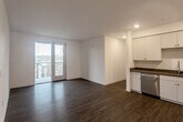 Located at 1547 Pacific Ave in Santa Cruz, CA, this modern 4-bedroom, 2-bathroom unit offers a thoughtfully designed single-floor layout. The open-concept living and kitchen area is anchored by warm hardwood-style flooring and recessed lighting throughout. Sliding glass doors lead to a private balcony, allowing natural light to pour into the living space and offering pleasant outdoor views of the surrounding neighborhood.

The kitchen is well-appointed with white shaker-style cabinetry, dark stone countertops, a stainless steel sink, and a full suite of stainless steel appliances including a refrigerator, range, microwave, and dishwasher. The clean, neutral palette creates a bright and functional cooking space.

The four bedrooms are comfortably sized, with the primary bedroom offering generous proportions and natural light from large windows. A walk-in closet with built-in shelving and hanging rods provides ample storage. The remaining bedrooms share access to the hallways and additional closet space.

Both bathrooms feature a consistent design with light wood-toned vanity cabinetry, dark stone countertops, large mirrors, and hardwood-style flooring. One bathroom includes a walk-in shower. The unit's clean, contemporary aesthetic and efficient layout make it a highly functional and attractive space in the heart of Santa Cruz.