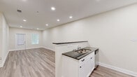 Located at 2200 Abbey Glen Ln in West Point, GA, this 1-bedroom, 1-bathroom residence offers a thoughtfully designed layout with modern finishes throughout. The open-concept kitchen and living area serves as the heart of the home, featuring light wood-look luxury vinyl plank flooring, recessed lighting, and a neutral warm-toned color palette that creates a clean, inviting atmosphere. The kitchen is well-equipped with white shaker-style cabinetry, dark granite countertops, stainless steel appliances including a range, microwave, refrigerator, and dishwasher, and a peninsula that provides both additional workspace and a natural division from the living area. The living room offers ample space with a front entry door and window that allow natural light to fill the room. A hallway connects the main living area to the private quarters, with a louvered door leading to a dedicated closet. The bedroom is a comfortable retreat finished with plush carpet flooring, a ceiling fan with light fixture, and access to a walk-in closet. The full bathroom features a tub-shower combination, toilet, and wood-look tile flooring. Clean white trim and baseboards are consistent throughout, lending the entire space a cohesive, polished look.