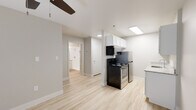 Located at 5520 N Union Blvd in Colorado Springs, Colorado, this single-floor unit offers a clean, modern aesthetic throughout its well-designed layout. Light wood-style flooring runs continuously across every room, creating a cohesive and airy feel.

The kitchen is efficiently arranged and features white shaker-style upper cabinets, granite-look countertops, a stainless steel electric coil range, an over-the-range black microwave, and a single-basin sink. A skylight panel above the kitchen provides additional brightness, complementing the recessed lighting throughout.

The living area is open and well-lit, benefiting from a large window with vertical blinds that allows generous natural light to fill the room. A ceiling fan overhead provides year-round comfort, while baseboard heating units along the walls ensure warmth during Colorado's colder months.

The bathroom is thoughtfully finished with a white vanity cabinet, granite-style countertop, a framed mirror with overhead lighting, a toilet, and a shower-tub combination. Towel bars and a curtain rod complete the functional layout.

Additional features include interior doors with classic panel detailing, a closet for storage, and a neutral warm-gray color palette on the walls that lends a calm, inviting atmosphere throughout the entire space.