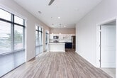 Located at 670 Meeting St in the heart of Charleston, SC, this single-floor residence offers a thoughtfully designed open-concept layout that seamlessly connects the living, dining, and kitchen areas. Light wood-tone flooring runs throughout the main living spaces, complemented by a neutral color palette that creates a clean and contemporary aesthetic.

The kitchen is a standout feature, showcasing two-tone cabinetry with crisp white upper cabinets and bold navy blue lower cabinets, topped with bright white quartz countertops. A large center island provides generous prep and seating space, while stainless steel appliances — including a refrigerator, range, microwave, and dishwasher — complete the modern finish. A classic subway tile backsplash adds texture, and pendant lighting above the island enhances the space's style.

The living area is generously proportioned, bathed in natural light through floor-to-ceiling windows fitted with horizontal blinds. A ceiling fan ensures year-round comfort. The bedroom features plush carpeting, large windows with outdoor views, and a ceiling fan, offering a serene retreat. The bathroom is well-appointed with white subway tile surrounding a soaking tub and shower combination, a navy vanity with chrome fixtures, and wood-look flooring. Additional storage is accessible via a louvered interior door.