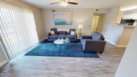 Located at Tanyard Park Place in Louisville, Kentucky, this single-floor unit offers a thoughtfully arranged layout that balances functionality with comfortable living. The entry foyer welcomes residents with wood-look flooring that extends throughout the main living areas, setting a cohesive tone for the space.

The living room serves as the central gathering area, featuring a ceiling fan with light fixture, a textured ceiling, and a large sliding glass door dressed with vertical blinds that allows generous natural light to fill the room. Adjacent to the living room, a dedicated dining area is defined by a pendant light overhead and shares the same warm flooring.

The galley-style kitchen is efficiently designed with white cabinetry, light countertops, and wood-look flooring. Black appliances, including a range, microwave, and refrigerator, provide a clean contrast, while a stainless steel sink adds a modern touch.

The bedroom features plush carpet, a ceiling fan, a natural light window with blinds, and ample wall space. The bathroom is bright and clean, showcasing a white vanity with storage, a large mirror, and a modern multi-bulb light bar above.