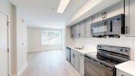 Located at 1 Hawaii Ave NW in Washington, DC, this efficiently designed studio offers a thoughtfully arranged single-floor layout that maximizes every square foot. Light-toned hardwood flooring flows throughout the main living area, creating a warm, cohesive aesthetic complemented by clean white walls and modern recessed and flush-mount lighting.

The kitchen is neatly integrated along one wall, featuring gray shaker-style cabinetry, white subway tile backsplash, white countertops, and a full suite of black appliances including a refrigerator, electric range, microwave, and dishwasher. The open-entry design keeps the kitchen connected to the main living space, enhancing the sense of openness.

The living area is bright and airy, highlighted by a large window dressed with vertical blinds that allows natural light to fill the room. Clean white baseboards and neutral walls provide a versatile backdrop for a variety of furnishing styles.

The bathroom is well-appointed with large-format light tile flooring, a wide vanity with gray cabinetry and a white countertop, and a full soaking tub with a white subway tile surround. The space is clean, modern, and functional. Overall, this studio presents a polished, contemporary living environment ideal for those seeking efficient city living in the DC area.