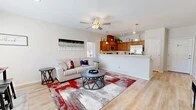 Located at 6601 Tree Line Ave NW in Albuquerque, New Mexico, this two-story, two-bedroom, three-bathroom home offers a thoughtfully designed layout spread across two floors. The main floor features an open-concept living, dining, and kitchen area with light hardwood-style flooring that creates a bright, cohesive feel throughout. The living room is anchored by a ceiling fan and flows seamlessly into the dining space, which is bathed in natural light from a large window. The kitchen is well-appointed with warm wood cabinetry, stainless steel appliances including a range, microwave, and refrigerator, generous counter space, and a breakfast bar that connects it to the living area. Pendant lighting and track lighting add a polished touch overhead. Upstairs, the primary bedroom is a generously sized retreat featuring plush carpet, a ceiling fan, ample natural light, and a private en-suite bathroom with a warm wood vanity. The second bedroom is equally comfortable with carpet flooring and its own ceiling fan. Three full bathrooms are distributed across both floors, each with tub-shower combinations and wood-style flooring. Additional features include four closets, a dedicated laundry area, and a staircase connecting both levels. The home presents a clean, modern aesthetic throughout with neutral tones and an efficient, functional floor plan.
