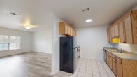 Located at 1300 Melody Ln in Remerton, Georgia, this single-floor residence offers a straightforward and functional layout designed for comfortable everyday living. The kitchen serves as a practical hub of the home, featuring light oak cabinetry, tile flooring, a full suite of black appliances including a refrigerator, range, built-in microwave, and dishwasher, along with ample counter space. A six-panel door off the kitchen provides convenient interior access. The kitchen opens toward a spacious living area finished with light wood-tone laminate flooring and a ceiling fan, with a window allowing natural light to fill the room. Multiple bedrooms continue the consistent design language, each featuring the same light laminate flooring, ceiling fans, and windows fitted with blinds. Two full bathrooms serve the home, each including a single-sink vanity with wood cabinetry, a tub-shower combination, and tile flooring. A dedicated laundry closet houses a full-size washer and dryer alongside a water heater, adding everyday convenience. Throughout, the home maintains a clean, neutral palette with white walls and white trim, creating a bright and cohesive atmosphere well-suited for a variety of living arrangements.