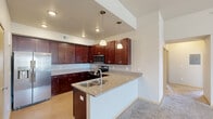 Located at 1755 Moon Meadows Drive in Rapid City, South Dakota, this single-story home offers five bedrooms and two bathrooms within a well-organized floor plan. The kitchen is a standout feature, showcasing rich dark cabinetry, granite countertops, a peninsula with an undermount sink, stainless steel appliances including a refrigerator, electric range, and built-in microwave, plus pendant lighting overhead. The layout transitions smoothly into the living area, which is finished with plush carpeting, a ceiling fan, and access to a private balcony through sliding glass doors, accompanied by a large window that fills the space with natural light and neighborhood views. The five bedrooms are carpeted and feature neutral walls; several include windows with exterior views, and at least one includes a closet with sliding doors and built-in shelving. The bathrooms are finished with dark vanity cabinetry, granite countertops, and a tub-shower combination with tile accents. A dedicated laundry room houses a full-size washer and dryer with overhead wire shelving, adding everyday convenience to this functional and comfortable Rapid City home.